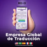 Mano sosteniendo un celular con la web de Roxo Traducciones; texto “Empresa Global de Traducción” y mención de múltiples idiomas disponibles.